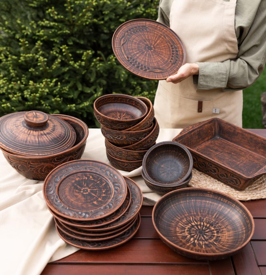 Rustic red clay serving set with casserole, plates and a baking dish